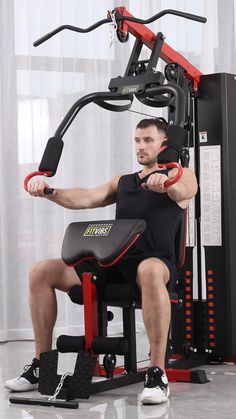 a man sitting on a bench in front of a gym machine with the arm extension extended