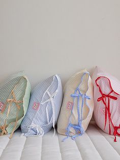 four pillows lined up in a row on top of a mattress with ties tied to them