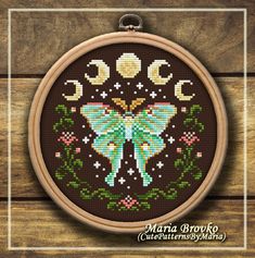 a cross stitch pattern with a butterfly in the middle and moon on it's back