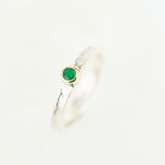 Tess, a beautiful gemstone Storybook ring set with your choice of sparkling gemstone. Featuring a rainbow of birthstone gems, Tess makes the perfect birthday gift. Set with the May birthstone, a beautiful green emerald. The storybook band is textured with the signature Storybook finish, a leather like design reminiscent of well loved and worn books. The edges move up and down organically as the silver gentle flows around your finger. They make the perfect ring worn on their own, or stacked with Round Birthstone Gemstones As Gifts, May Birthstone Gemstones With Accent Stones For Gifts, May Birthstone Gemstones With Accent Stones, Emerald Stackable Rings For May Birthstone, May Birthstone Stackable Round Stone Jewelry, May Birthstone Stackable Jewelry, Stackable May Birthstone Jewelry With Round Stones, Stackable Round Stone Jewelry For May Birthstone, Round Gemstone Birthstone Ring For Gift