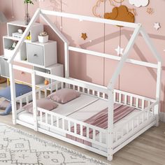 a child's bedroom with pink walls and white wooden furniture, including a doll house bed