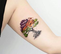 a woman's arm with a colorful tree tattoo on it