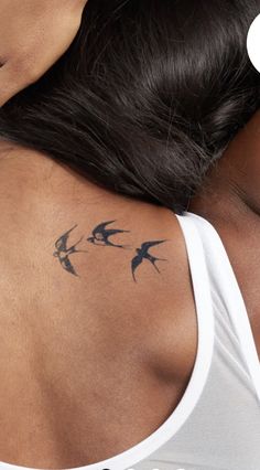 the back of a woman's shoulder with birds on it