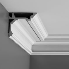 the corner of a ceiling with white trim and black brackets on it's sides