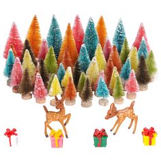 a group of small christmas trees with deer figurines next to them and presents