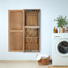 a washer sitting next to a dryer in a room with wooden cabinets on the wall