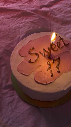 a cake with the word sweet on it and a lit candle sticking out of it