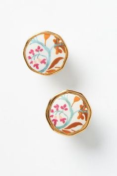 two pairs of earrings with floral designs on them