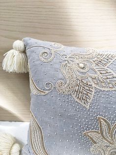 a decorative pillow with tassels on it