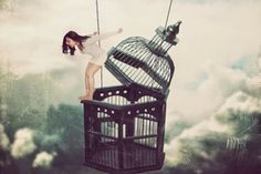 a woman standing on top of a bird cage