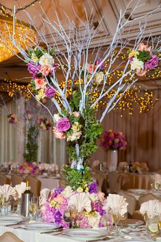 the centerpiece is decorated with flowers and branches