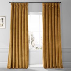 a gold colored curtain hanging in front of a window with white walls and flooring