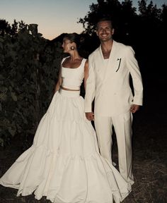 a man and woman dressed in white standing next to each other