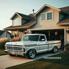 an old silver truck parked in front of a house