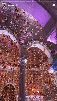 the ceiling is decorated with flowers and streamers in pink, purple, yellow and white colors