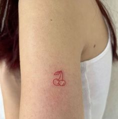 a woman's arm with a small red tattoo on the left side of her arm