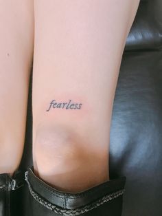 a woman's leg with the word fearless tattooed on it