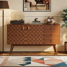 a living room with a rug, lamp and wooden cabinet in it's center