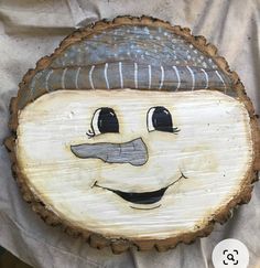 a wood slice with a face painted on it