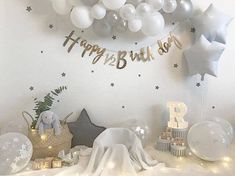 a birthday party with balloons and stars on the wall, including an elephant cake topper