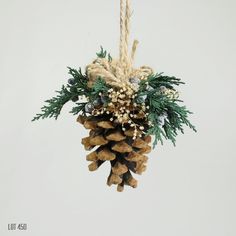 a pine cone ornament hanging from a rope