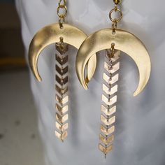 "These dangle earrings have a bit of a boho vibe with lots of bronze shimmer! I designed these drop earrings with bronze half moons made of stainless steel. Attached is a string of arrow chain with each earring measures about 3\" in length and 1\" in width at the widest point on the half moon.                                   ** If you like these, check out my half moon, star and gemstone earrings found here ** https://www.etsy.com/listing/1601797459/half-moon-dangle-earrings-with-crystal?click_key=4c46dc3412ec55d4bea0d900d061c6ec9c6b5cb4%3A1601797459&click_sum=62966322&ref=shop_home_active_1&pro=1" Bohemian Bronze Chandelier Earrings With Ear Wire, Handmade Brass Dangle Chandelier Earrings, Handmade Brass Chandelier Dangle Earrings, Gold Moon Charm Earrings For Festival, Bohemian Brass Earrings With Moon Charm, Festival Jewelry With Gold Dangling Charms, Gold Festival Jewelry With Dangling Charms, Gold Copper Festival Earrings, Gold Jewelry With Dangling Charms For Festival