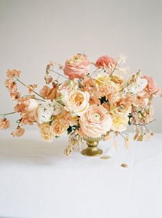 a vase filled with lots of flowers on top of a table