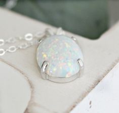 "Beautiful Large white lab-created opal pendant necklace. These gorgeous opals are very similar to natural mined opals. Lab-created opals contain 70-90% silica (from which natural opal is formed) and 10-30% resin. The resin makes the opal harder, stronger, unlike natural opals, which are known to be soft and fragile. Each opal displays a rainbow of color that sparkles with every catch of light. I've handset two different size opals in a solid sterling silver prong settings 16x12mm (5/8\" x 1/2\" White Opal Round Pendant Necklace, White Opal Pendant Jewelry, White Opal Gemstone Necklace, White Oval Opal Necklace, White Opal Necklace For Gift, White Pink Opal Gemstone Jewelry, White Ethiopian Opal Gemstone Jewelry, White Ethiopian Opal Gemstone Necklace, White Opal Cabochon Necklaces