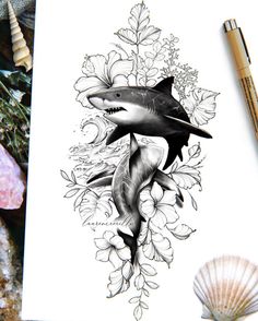 a drawing of a shark and flowers on paper next to shells, pencils and seashells