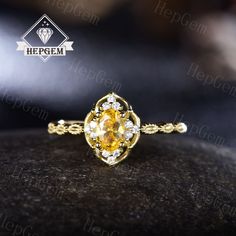 a yellow diamond ring sitting on top of a black stone surface with the words hegem written above it