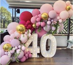 balloons and greenery decorate the number ten sign