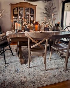 a dining room table with chairs and candles