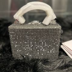 Color: Grey Dimensions: 5.8”W X 4.3”H X 3"D Handle Drop: 3" Shoulder Strap: 18”-22” Mini Handbag/ Cross-Body Bag Buckle-Clasp Fastening Hand-Sewn Double Stitched Handle Adjustable, Detachable, Leather, Cross-Body, Strap Dust Bag Included Imported Composition Material: Rhinestone, 100% Cowhide Leather, 100% Cotton Canvas Hardware: Silver Metalware Lining: Microsuede Item Care Do Not Machine Wash Do Not Bleach Do Not Tumble Dry Do Not Iron Do Not Dry Clean Luxury Silver Box Bag, Luxury Silver Box Bag For Shopping, Luxury Silver Rectangular Box Bag, Designer Silver Box Bag For Evening, High-end Top Handle Box Bag For Party, Luxury Box Bag With Top Carry Handle For Party, Luxury Party Box Bag With Top Carry Handle, Luxury Silver Box Bag For Party, Luxury Square Box Bag For Party