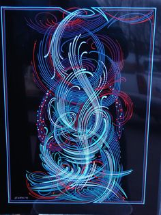 a blue and red light painting on a black glass block with an abstract design in the middle