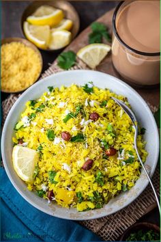 a white bowl filled with rice next to lemons and other food on a table