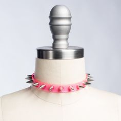 Classic choker collar with a colorful twist. Silver 1/2" spikes riveted evenly throughout. Adjustable buckle in back. Available in PVC, leather, or vegan leather. An essential item for any goth or punk who likes a little bit of color, festival or clubkids-inspired looks. Collar is 1/2" wide. Shown in neon pink PVC. Silver-toned nickle plated steel hardware. Neon pink and neon orange PVC are UV/Blacklight reactive. SMALL/MEDIUM (11-13")MEDIUM/LARGE (13-15")LARGE/X-LARGE (15-17") Custom sizing ava Adjustable Emo Choker For Alternative Fashion, Punk Choker For Halloween Festival, Adjustable Emo Choker For Concerts, Gothic Spiked Choker For Festivals, Party Choker With Spikes, Edgy Adjustable Choker For Party, Adjustable Edgy Party Choker, Punk Halloween Festival Choker, Punk Spikes Choker For Party