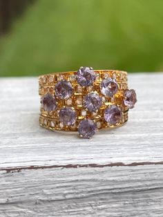 Unique 18 karat Yellow Gold Harem Stacking Ring featuring sparkly synthetic color changing sapphires (purple to turquoise color change) and diamonds METAL: 18 karat SIZE: 6 - sizing is not recommended due to nature of ring ERA: 1960s/1970s CONDITION: good vintage condition - stones securely set Kennedy's Cache sells curated antique and vintage pieces. Most have been preowned and loved and will have some signs of age and wear. We will disclose any flaws that would be out of the ordinary for age o Luxury Gold Amethyst Ring With Rose Cut Diamonds, Purple Sapphire Multi-stone Ring With Diamonds, Gold Amethyst Rings With Rose Cut Diamonds, Purple Diamond Jewelry With Rose Cut Diamonds, Gold Sapphire Ring With Rose Cut Diamonds Cluster, Purple Diamond Jewelry With Rose Cut, Gold Amethyst Ring With Rose Cut Diamonds For Anniversary, Amethyst Diamond Ring With Rose Cut Diamonds For Anniversary, Gold Multi-stone Diamond Amethyst Ring