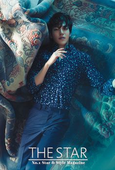 a young man laying on top of a bed next to an elephant pillow and blanket