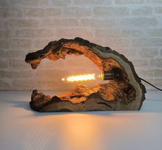 a light that is sitting on top of a wooden object with a wire attached to it