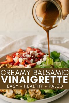 a plate filled with salad and dressing being drizzled on top of it