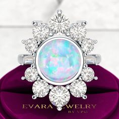 an opal and diamond ring on top of a purple velvet box with the words evara jewelry