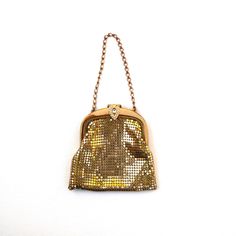 This is a beautiful antique gold mesh evening purse by Whiting and Davis Bags, made in USA. The clasp works perfect and it is decorated with a lovely gold tone and white crystals ornate detail / on the front of the lock. To open the purse, you need to lift up on the stone piece and it will pop open. The bag is lined with satin lining and hand stitched to the frame. This bag is an estate sale find. It has some stain on the lining along the top, one of the rhinestone is missing on the decorative lock part. Please see photos for reference. The purse is about 7 1/2" tall from top of the chain to the bottom of the purse. It is about 4 1/4" wide at the widest bottom points of the purse. More vintage bags and fashion accessories in my shop https://www.etsy.com/shop/AGardenCottage?ref=seller-platf Gold Clutch Coin Purse For Evening, Gold Evening Clutch Coin Purse, Gold Coin Purse Clutch For Wedding, Gold Clutch Coin Purse For Formal Occasions, Gold Clutch Coin Purse For Wedding, Formal Gold Clutch Coin Purse, Rectangular Gold Coin Purse For Evening, Vintage Evening Bag For Party, Antique Gold Evening Bag For Formal Events