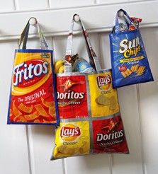 three bags hanging from the side of a door with chips and chips in them on it