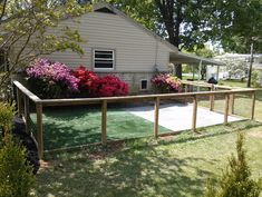 a fenced in yard with flowers on the lawn