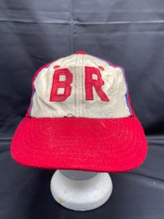 Vintage 1950's Felt Little League Baseball Hat Step up to the plate with this vintage 1950's felt Little League baseball hat. With a classic cap style, this red hat is perfect for any sports enthusiast. The hat comes in size S and is a great accessory for any vintage lover. Its unique design and charming appeal make it a great addition to any collection. Vintage Red Six-panel Baseball Cap, Retro Curved Brim Hat For Sports Events, Vintage Sports Fitted Hat With Curved Brim, Vintage Baseball Cap For Baseball Season, Vintage Baseball Cap With Curved Brim, Vintage Sports Snapback Hat With Curved Brim, Vintage Snapback Hat For Baseball Season With Curved Brim, Vintage Snapback Hat With Curved Brim For Sports, Vintage Curved Brim Snapback Hat For Baseball Season