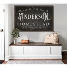 a black and white sign hanging on the wall above a wooden bench with a purse next to it