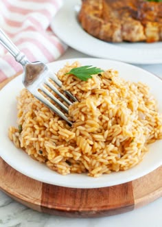 a fork is stuck into some rice on a plate