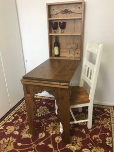 a wooden table with two chairs next to it and a wine bottle on the shelf