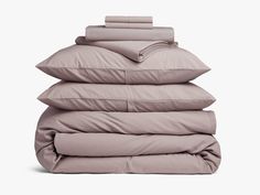 four pillows stacked on top of each other in front of a white background with the sheets folded down