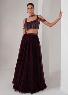 This stunning Black Platinoir Crepe Embellished Lehenga Set exudes modern elegance and glamour. Crafted from luxurious platinoir crepe, the black lehenga features a dramatic full-length skirt with all-over metallic brazen fall detailing, adding a shimmering effect with every movement. The crystal-embroidered waistband accentuates the waist, offering a refined silhouette. Teamed with a cold shoulder blouse, the ensemble reaches new heights with its halo crystal tassel embellishments, delivering a unique and stylish twist. The look is completed with a choker-style embellished dupatta, perfectly complementing the outfit with a sophisticated touch. Ideal for Cocktail parties, Sangeet nights, or evening events, this lehenga set is designed for those who wish to make a bold and fashionable state Choker Dupatta Lehenga, Fitted Georgette Evening Skirt, Evening Fitted Georgette Skirt, Festive Floor-length Embellished Skirt, Embellished Floor-length Festive Skirt, Embellished Skirt For Festive Reception, Embellished Skirt For Reception And Festive Occasions, Festive Embellished Skirt For Reception, Black Indowestern For Women